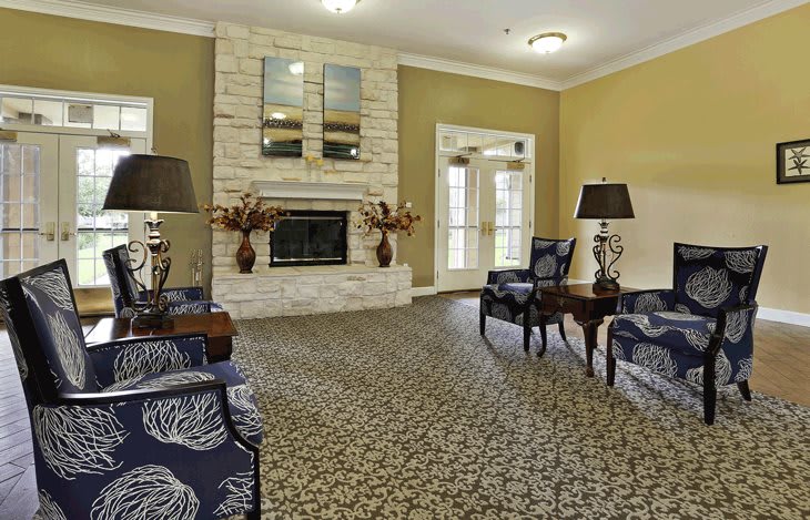 A cozy living room with elegant furniture and a central fireplace.