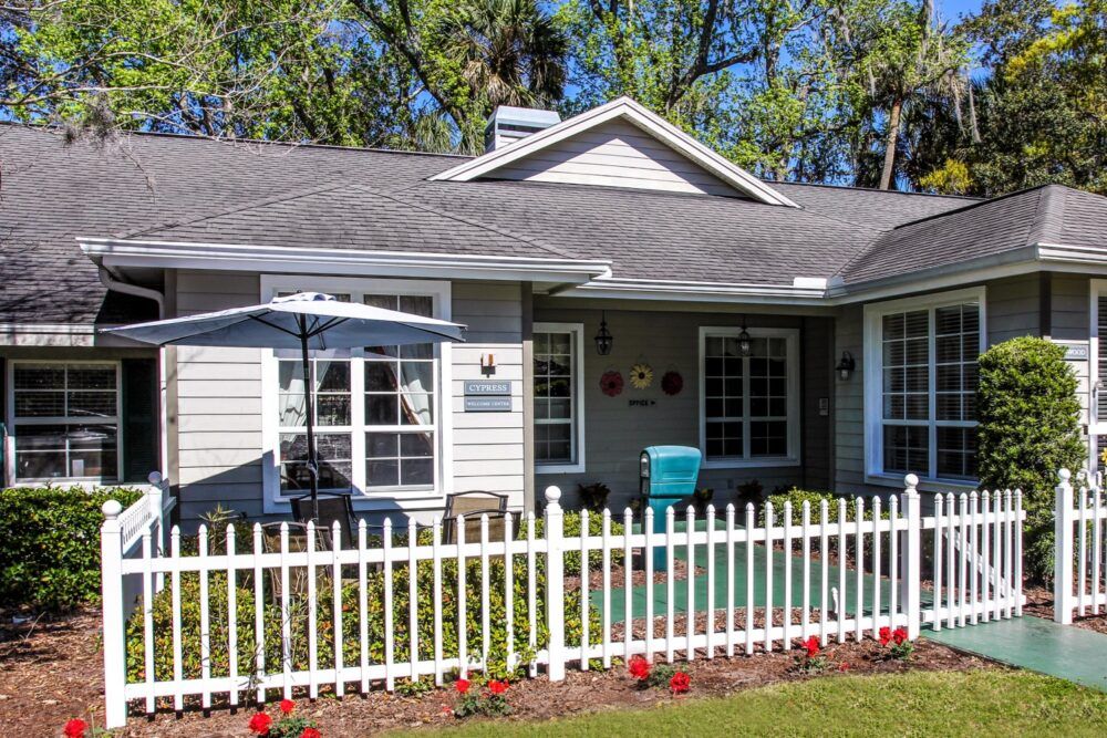 A charming suburban house with a white picket fence and a well-maintained garden.