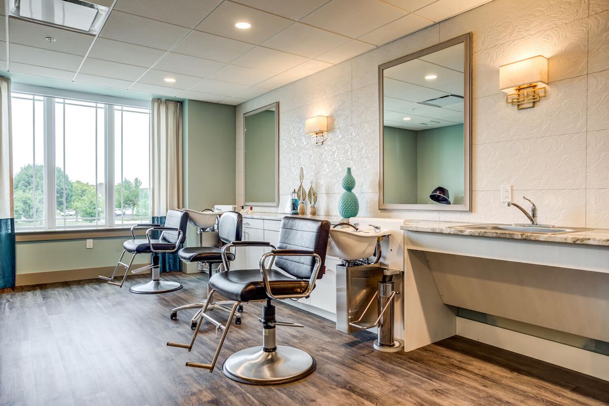 A modern salon interior with styling chairs and large mirrors.