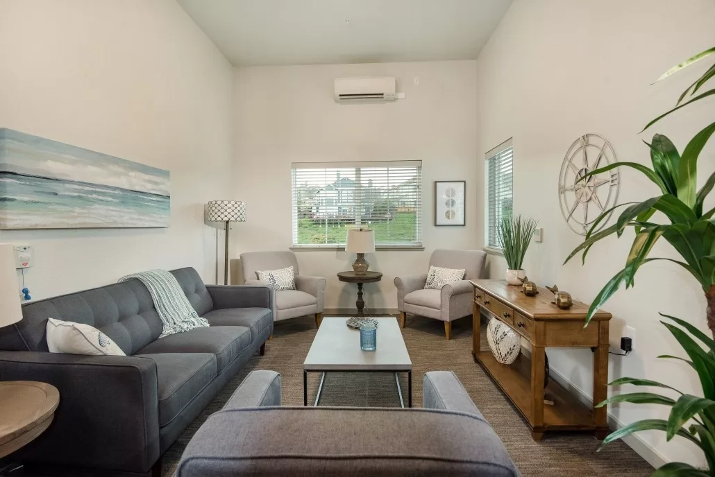 A modern living room with a cozy arrangement of sofas, chairs, and decorative elements.