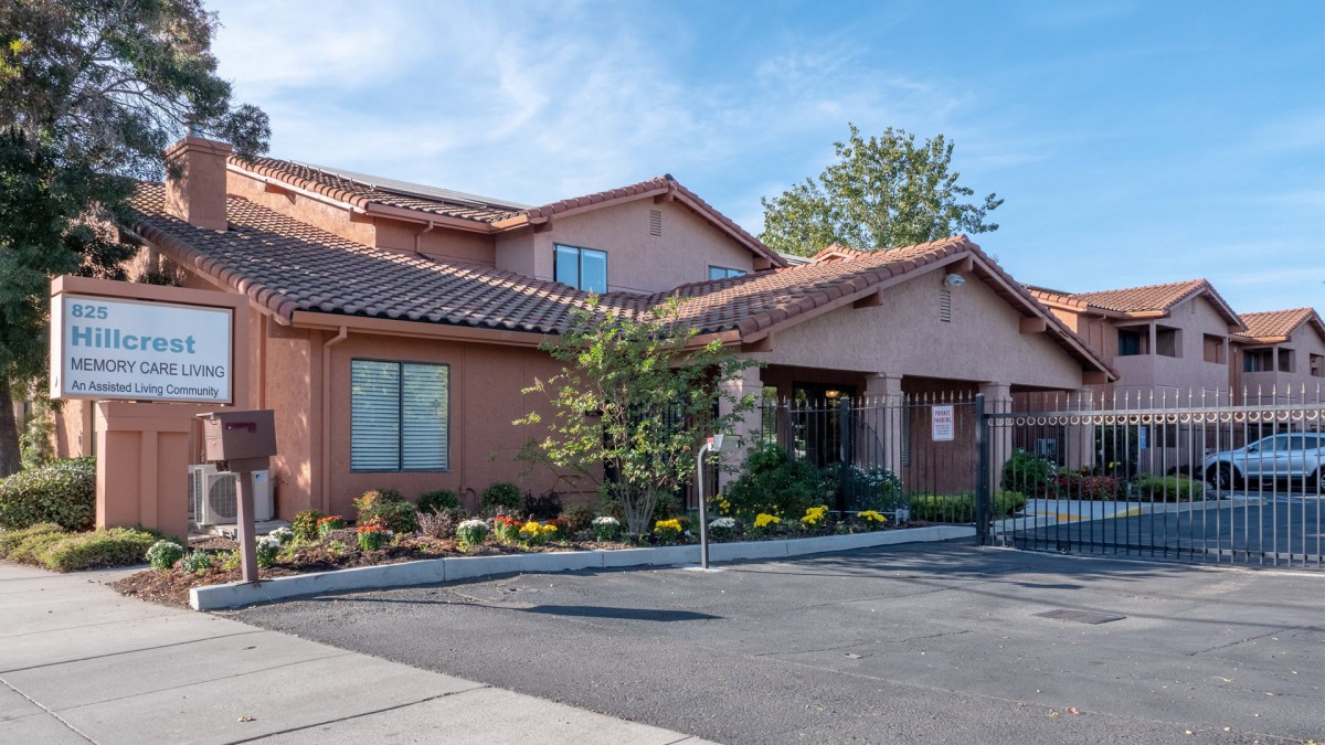 A suburban residential building with a tiled roof and landscaped surroundings.
