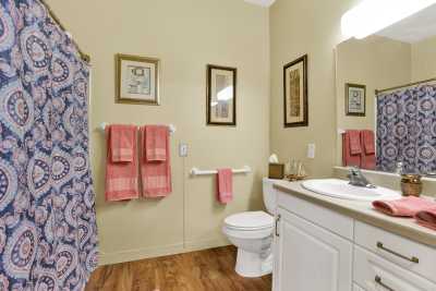A neatly arranged bathroom featuring a toilet, sink, and decorative towels.