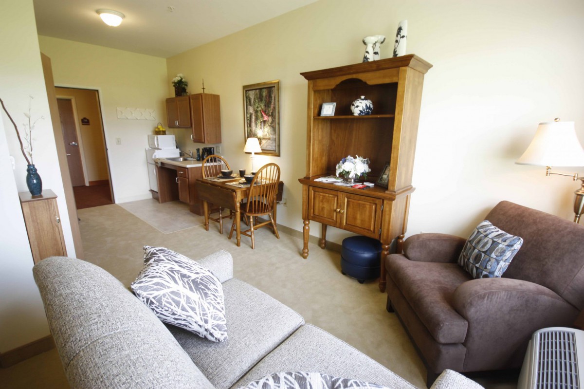 A cozy living room with a wooden desk and shelf, adorned with decorative items.