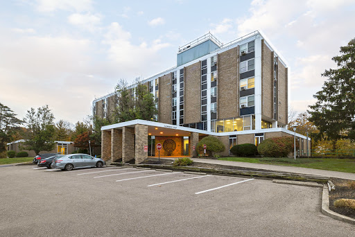 A modern hotel building with a well-defined entrance and ample parking space.
