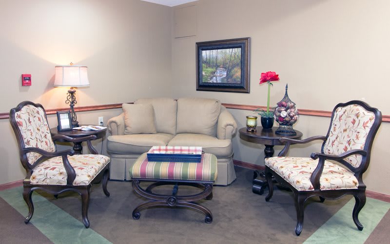 A cozy living room with a sofa, coffee table, and armchairs arranged around it.