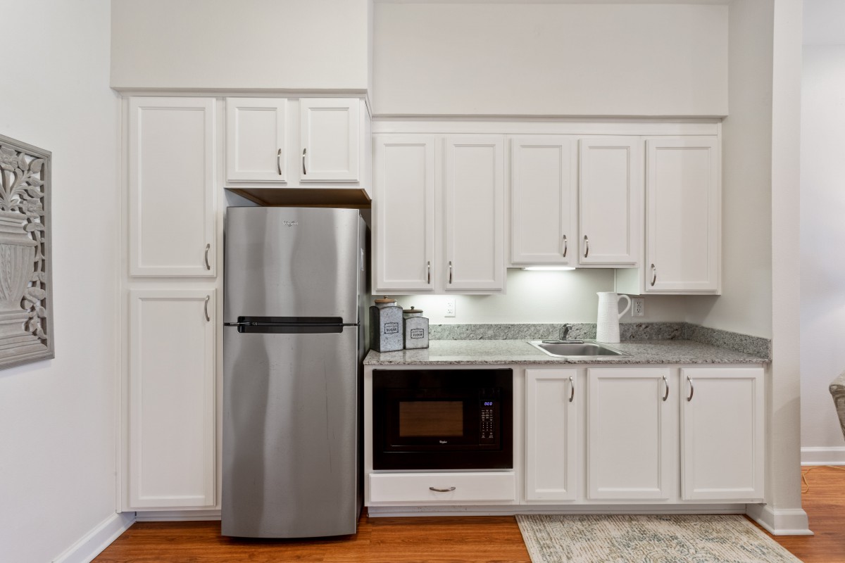Modern kitchen with stainless steel refrigerator and built-in microwave.