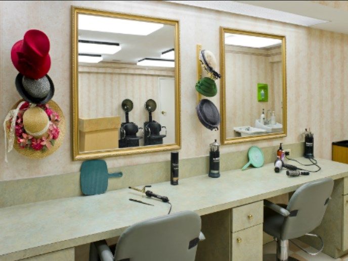 A well-equipped salon with mirrors, hair dryers, and chairs ready for customers.