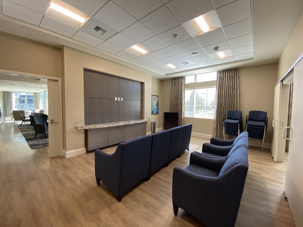 A modern waiting room with comfortable seating and a large television.