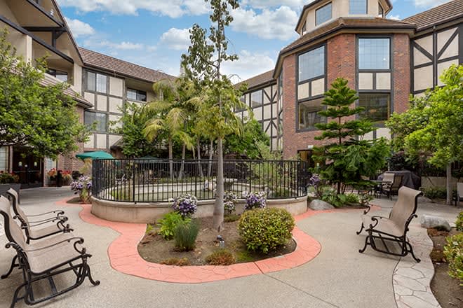 A view of a landscaped courtyard surrounded by a multi-story building.