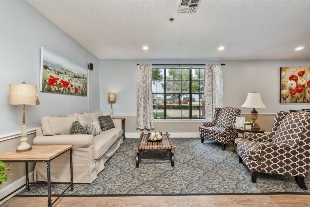 A cozy living room with a comfortable sofa, patterned armchairs, and a stylish coffee table on a decorative rug.