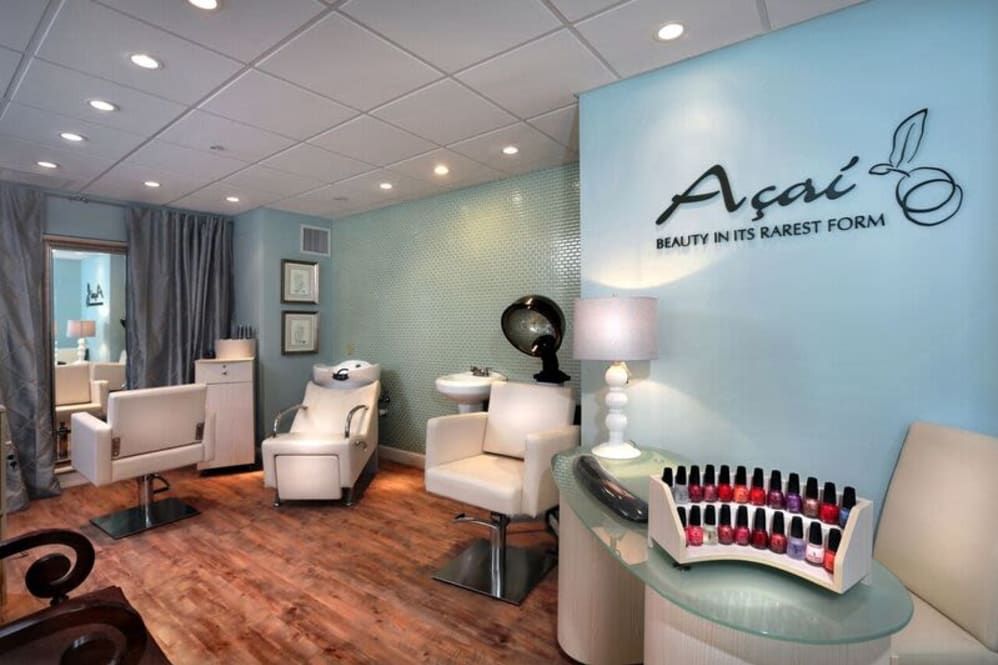 Interior of a modern beauty salon with manicure stations and comfortable seating.