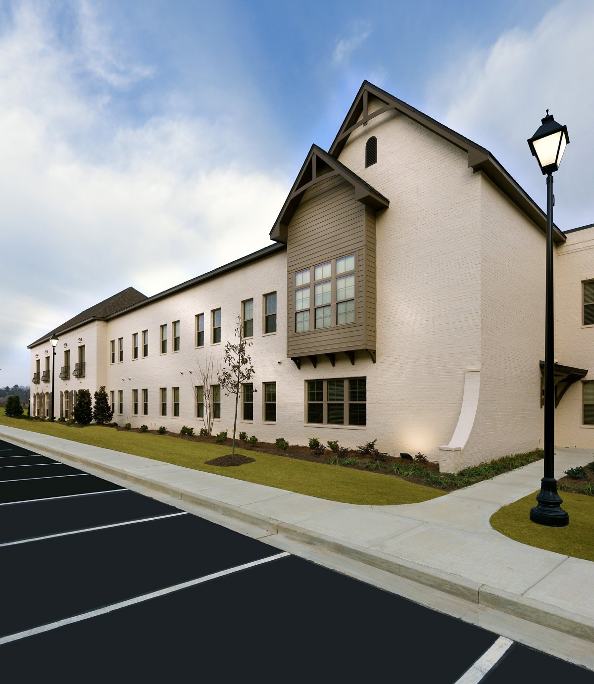 A modern building with a parking lot on a clear day.