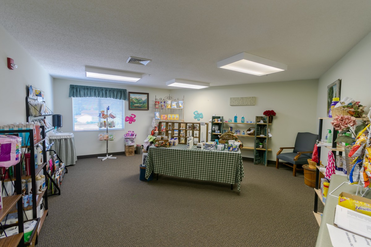 A spacious office interior with a table and shelves displaying various items.