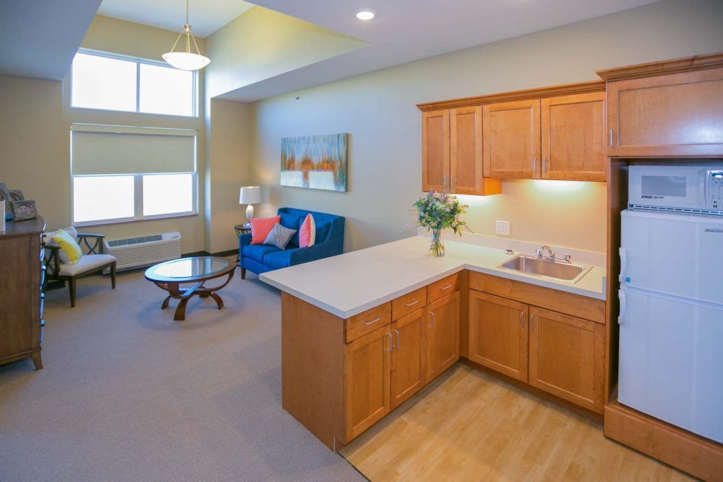 A modern apartment with an open floor plan featuring a cozy living room and a compact kitchen.