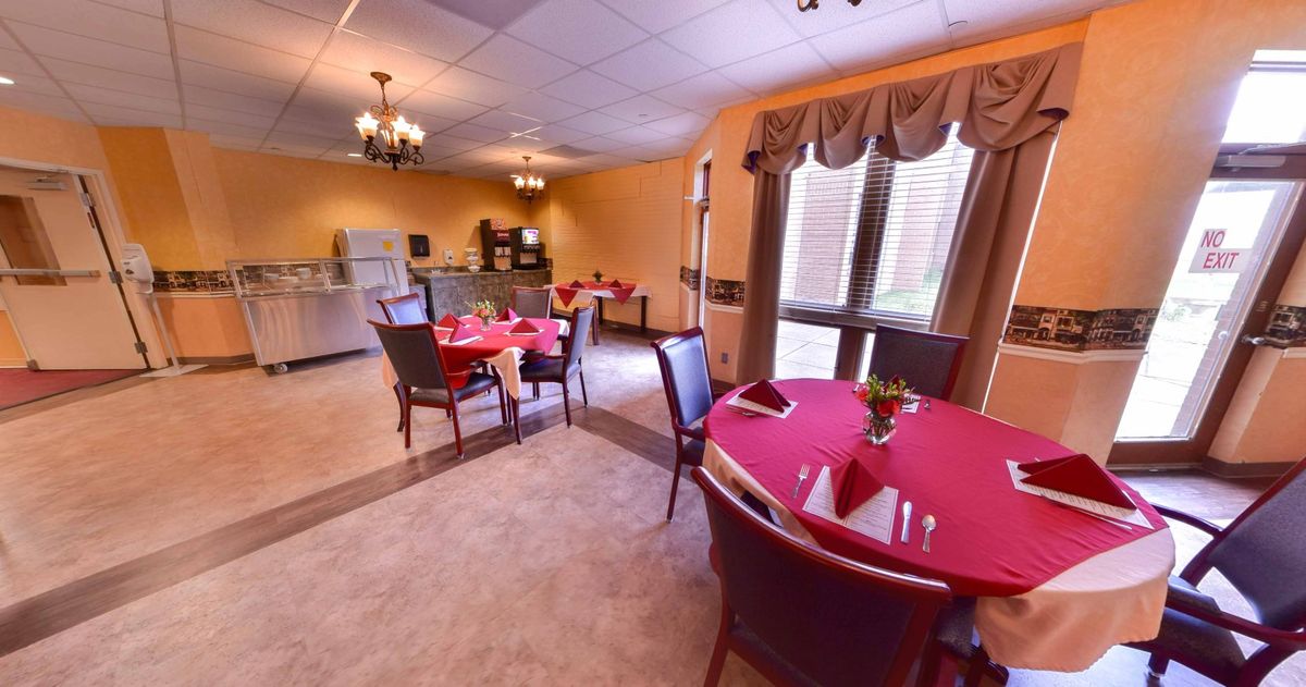 A cozy dining room with elegantly set tables and soft lighting.