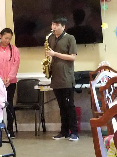 A young musician performs on the saxophone during a community event.