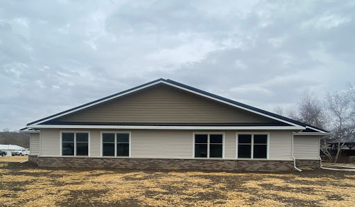 A modern residential building with a sleek design against a cloudy sky.