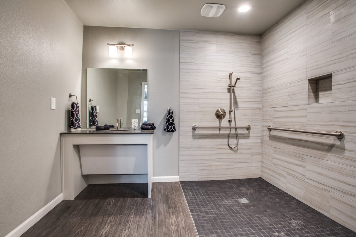 Modern accessible bathroom with a walk-in shower and safety grab bars.