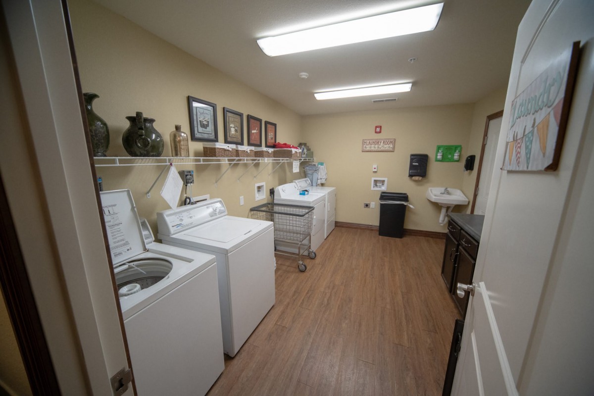 A well-organized laundry room with washing machines and a dryer.