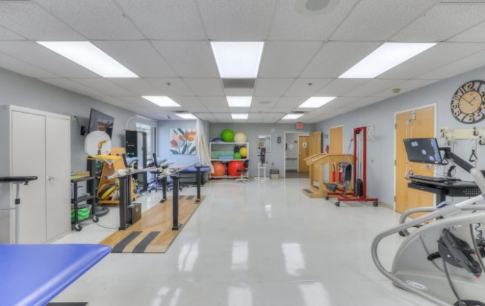 An empty fitness and rehabilitation gym equipped with various exercise machines and therapy tools.