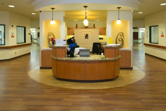 A modern reception area with a wooden desk and decorative lighting.