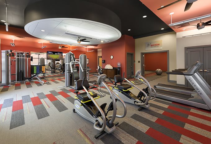 A modern gym interior with various exercise equipment and a colorful design.