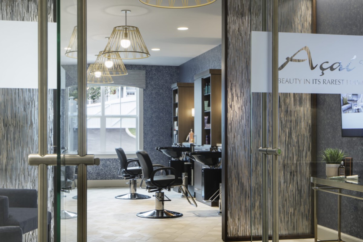 A modern hair salon with stylish chairs and mirrors, featuring contemporary lighting fixtures.