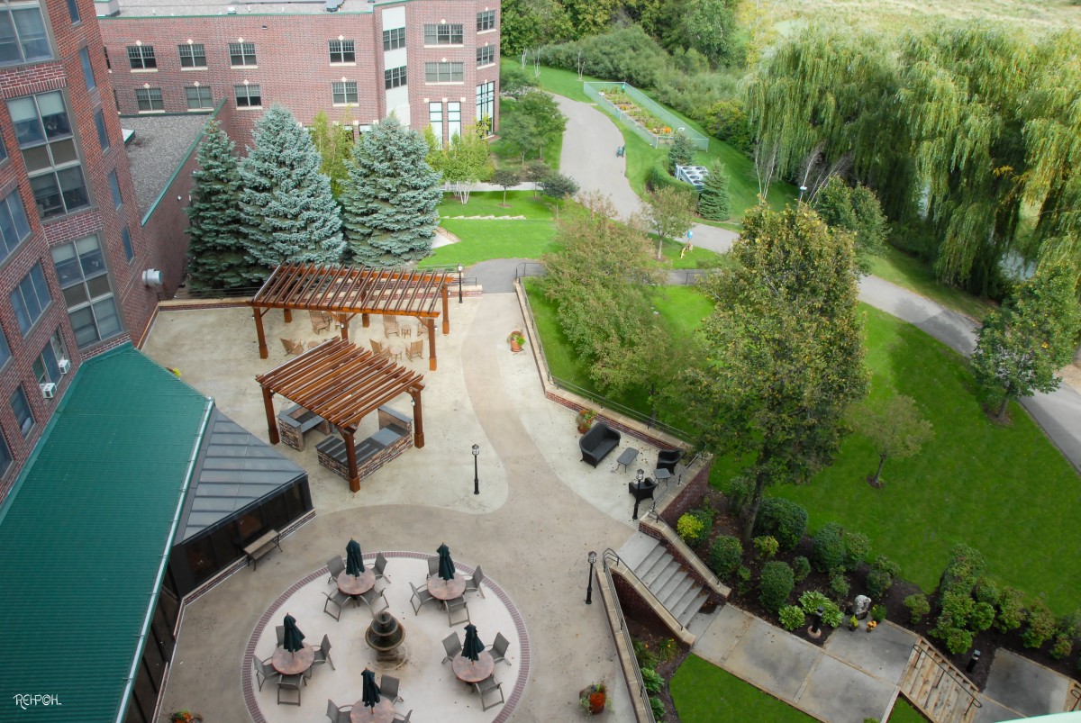 Aerial view of an outdoor patio area surrounded by lush greenery and walking paths.