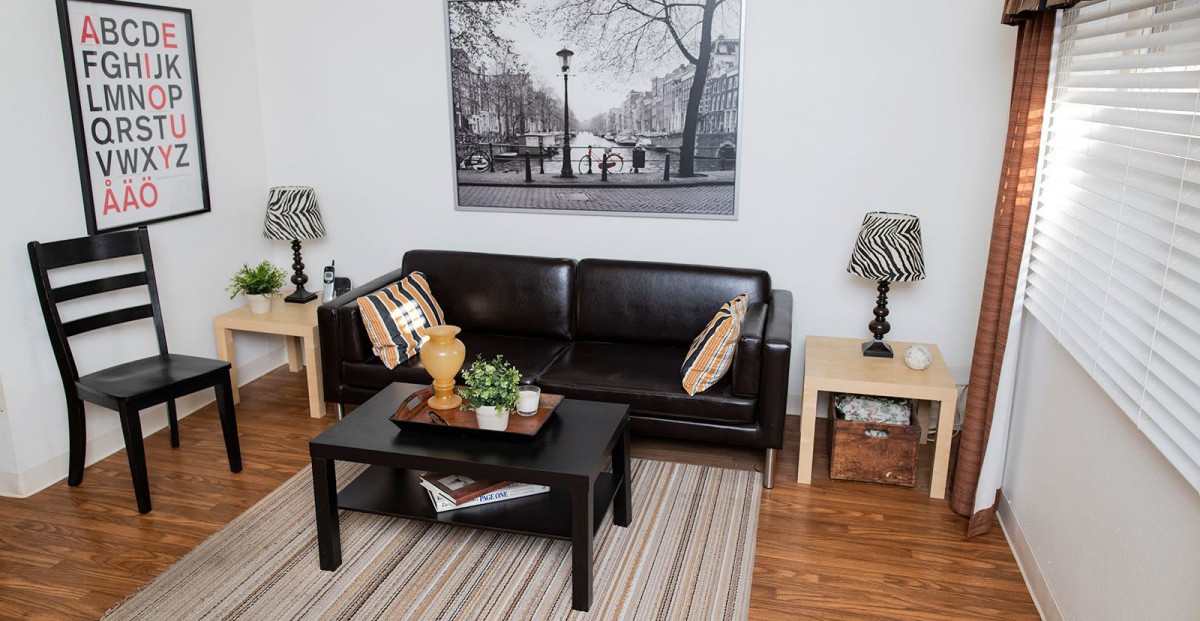 A cozy living room with a black leather sofa, coffee table, and decorative accents.