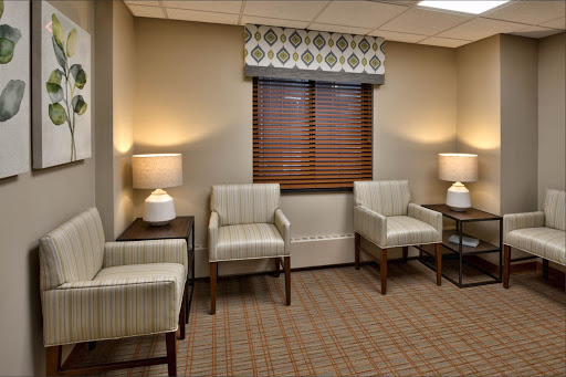 A cozy waiting area featuring patterned chairs, soft lighting, and a warm atmosphere.