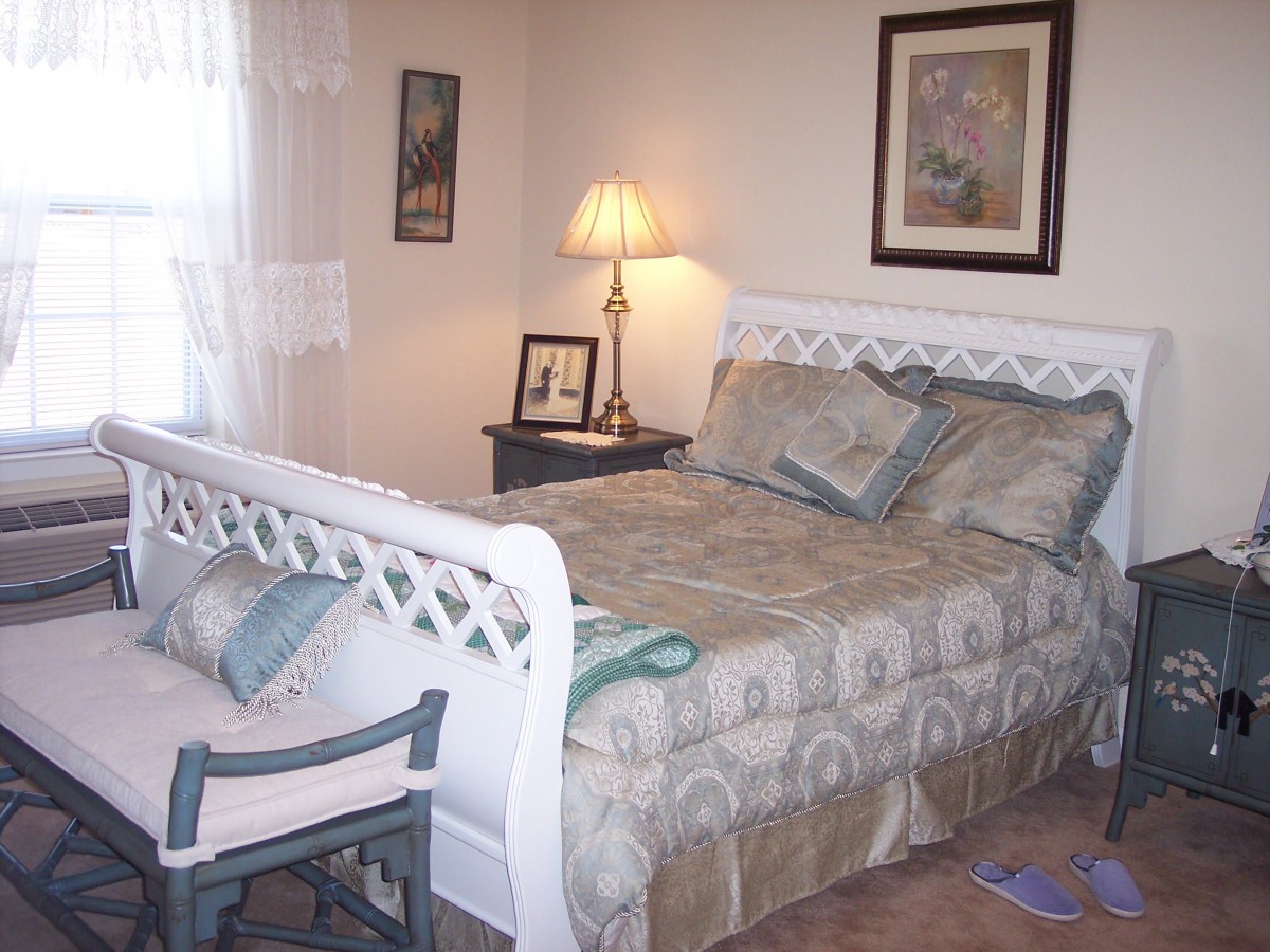 A cozy bedroom with a neatly made bed and warm lighting.