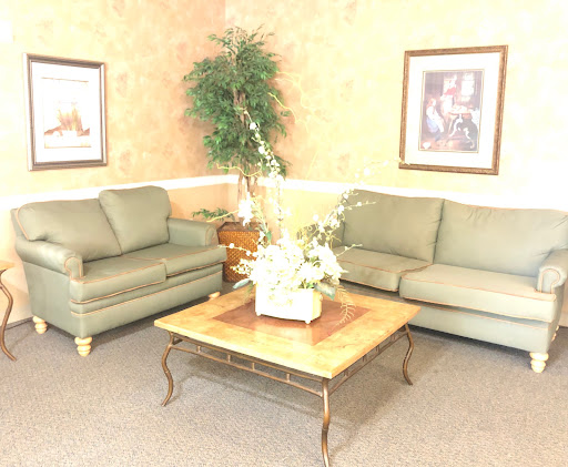 A cozy living room setup featuring green sofas, a wooden coffee table, and decorative elements.