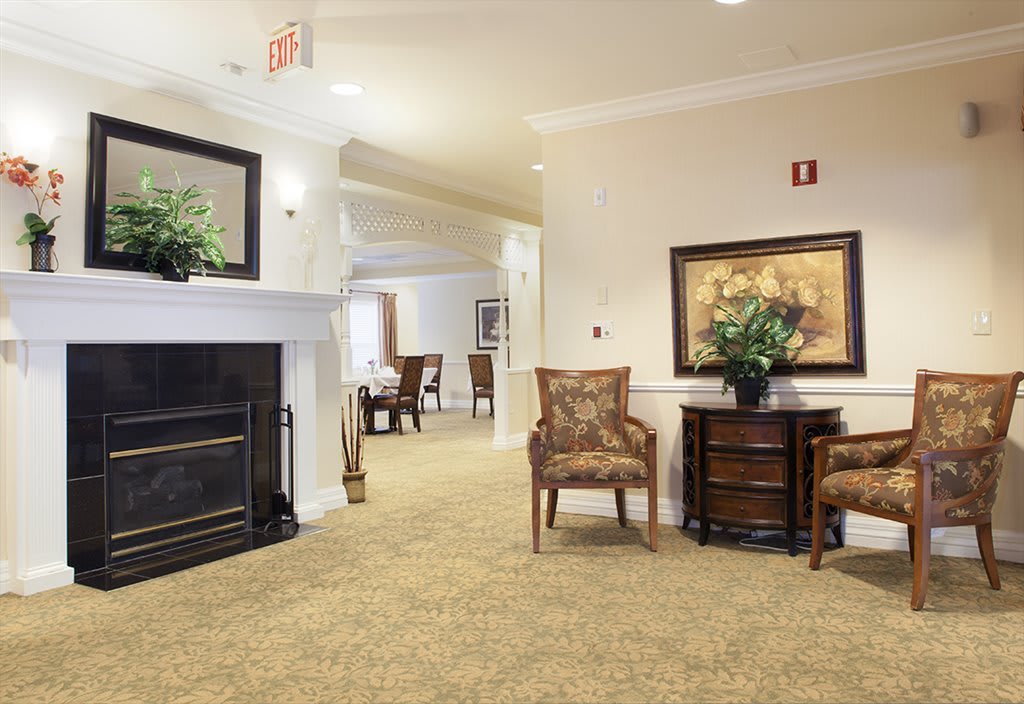 A cozy lobby area featuring a fireplace, comfortable chairs, and elegant decor.