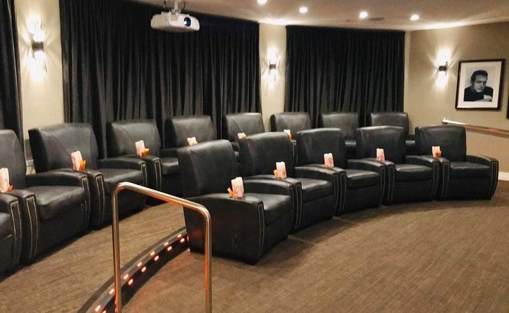 Luxurious home theater with recliner seating and projector.