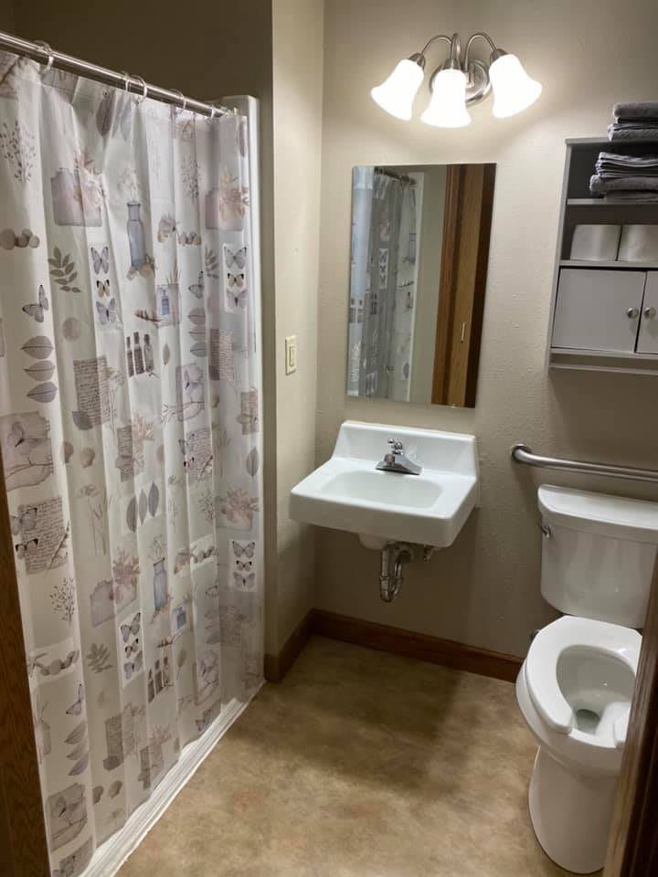 A compact bathroom with a sink, toilet, and shower.