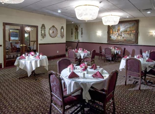 A beautifully arranged dining room featuring elegant tables and chandeliers, perfect for a sophisticated dining experience.