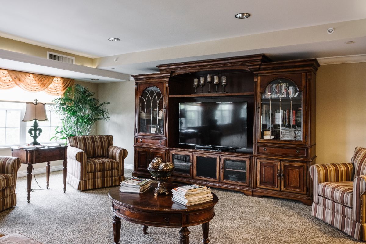 A cozy living room with a large wooden entertainment center and comfortable seating.