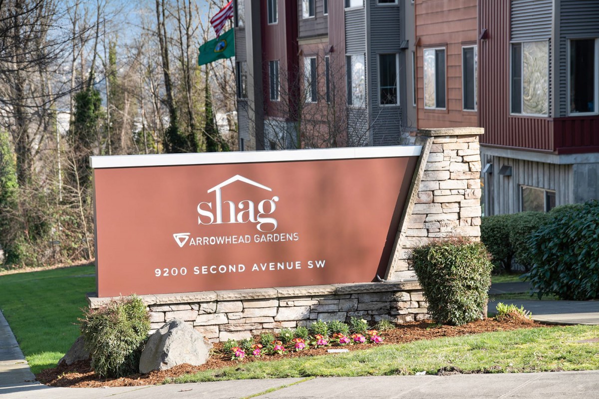 Signage for a senior living community in front of an apartment building.