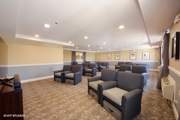 A well-lit seating area with multiple armchairs arranged on a carpeted floor, suitable for meetings or waiting.