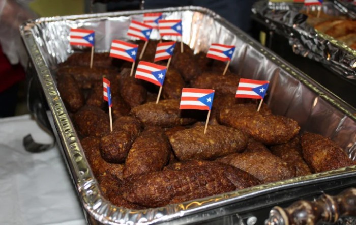 A tray of Puerto Rican fritters garnished with small Puerto Rican flags.
