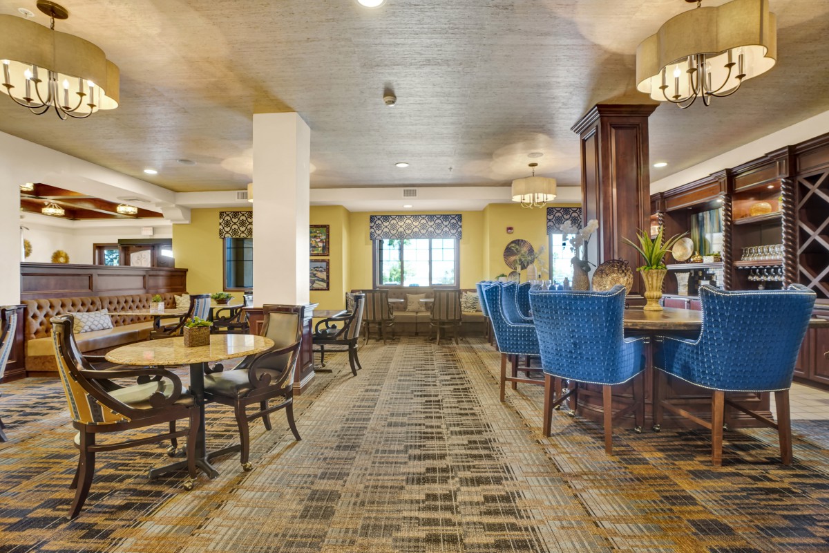 A spacious hotel lounge with elegant furniture and a cozy dining area.