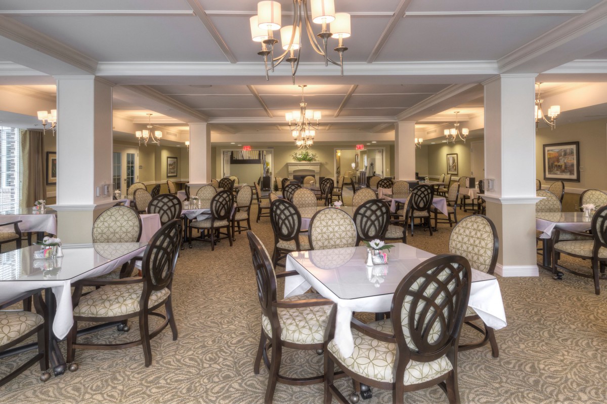 An elegantly furnished dining room with multiple tables and chairs, ready for guests.
