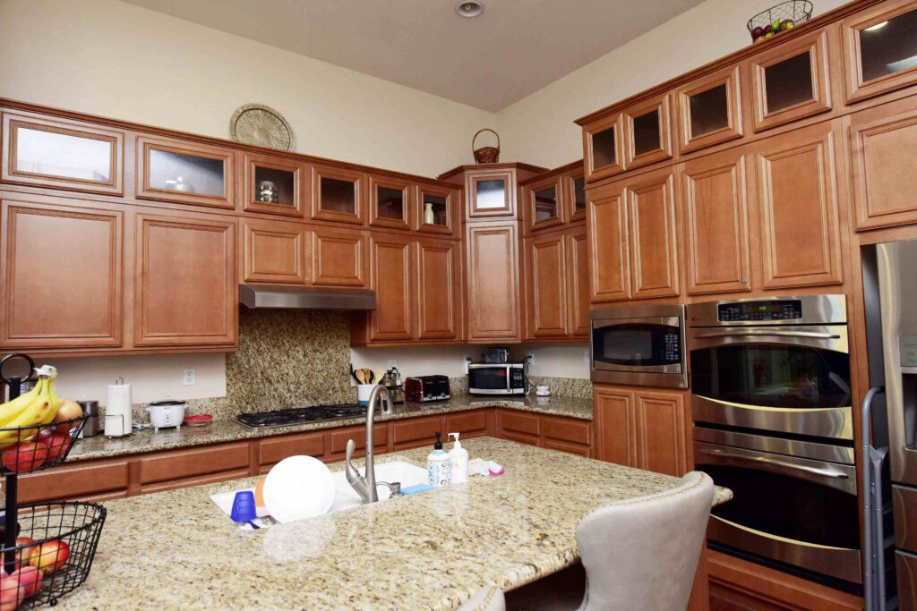 A modern kitchen with wooden cabinets and a granite countertop.