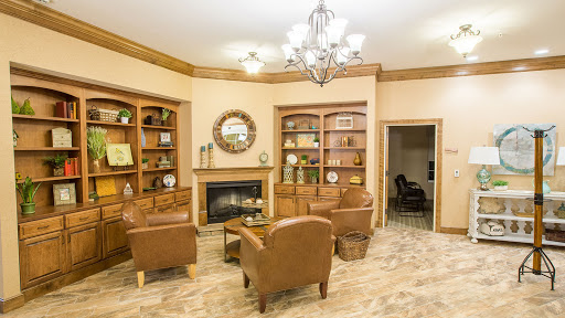 A cozy living room with warm tones, featuring comfortable leather chairs and a decorative fireplace.