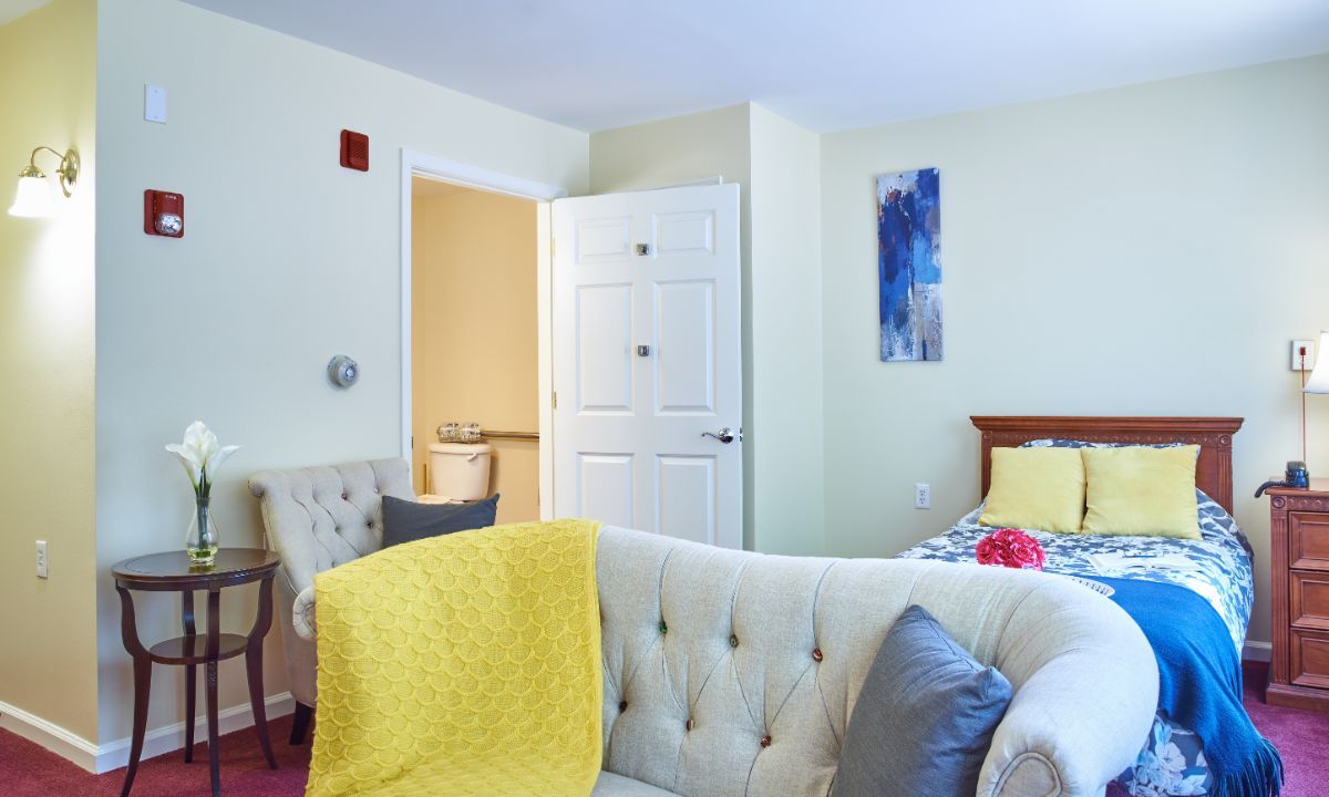 A cozy bedroom with bright yellow accents and comfortable furniture.