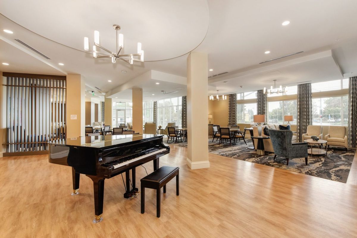 A spacious lobby with a grand piano and dining area.