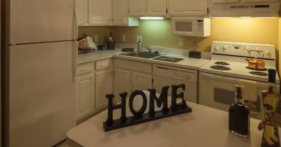 A cozy kitchen featuring a 'HOME' sign on the counter.