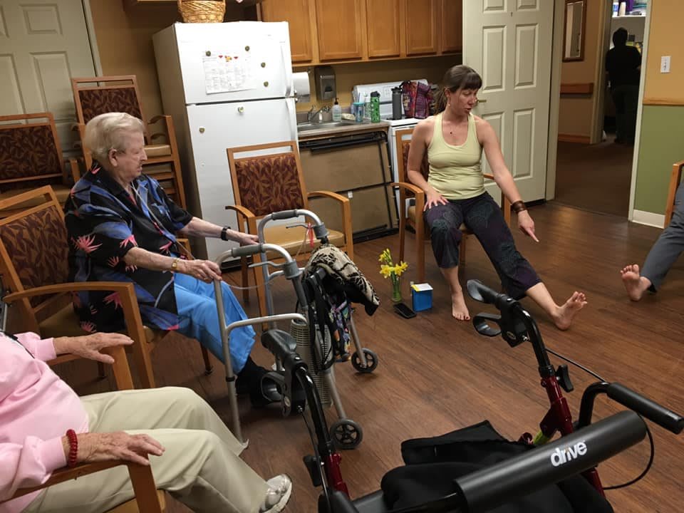 A group of people engaged in a physical therapy session in an indoor setting.