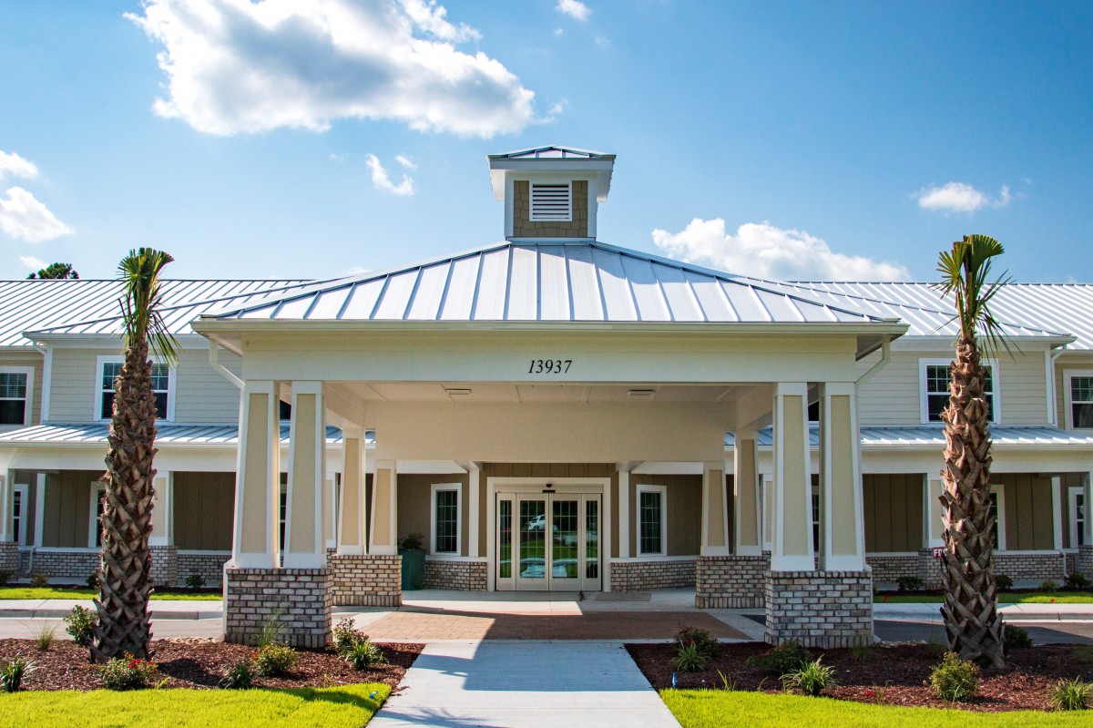 A modern building entrance with a covered porch and landscaped surroundings.