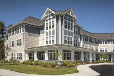 A modern residential building with large windows and well-maintained landscaping.